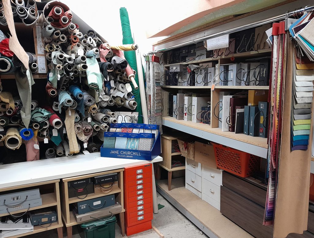 A fabric library with roles of fabric and samples for furniture upholstery.